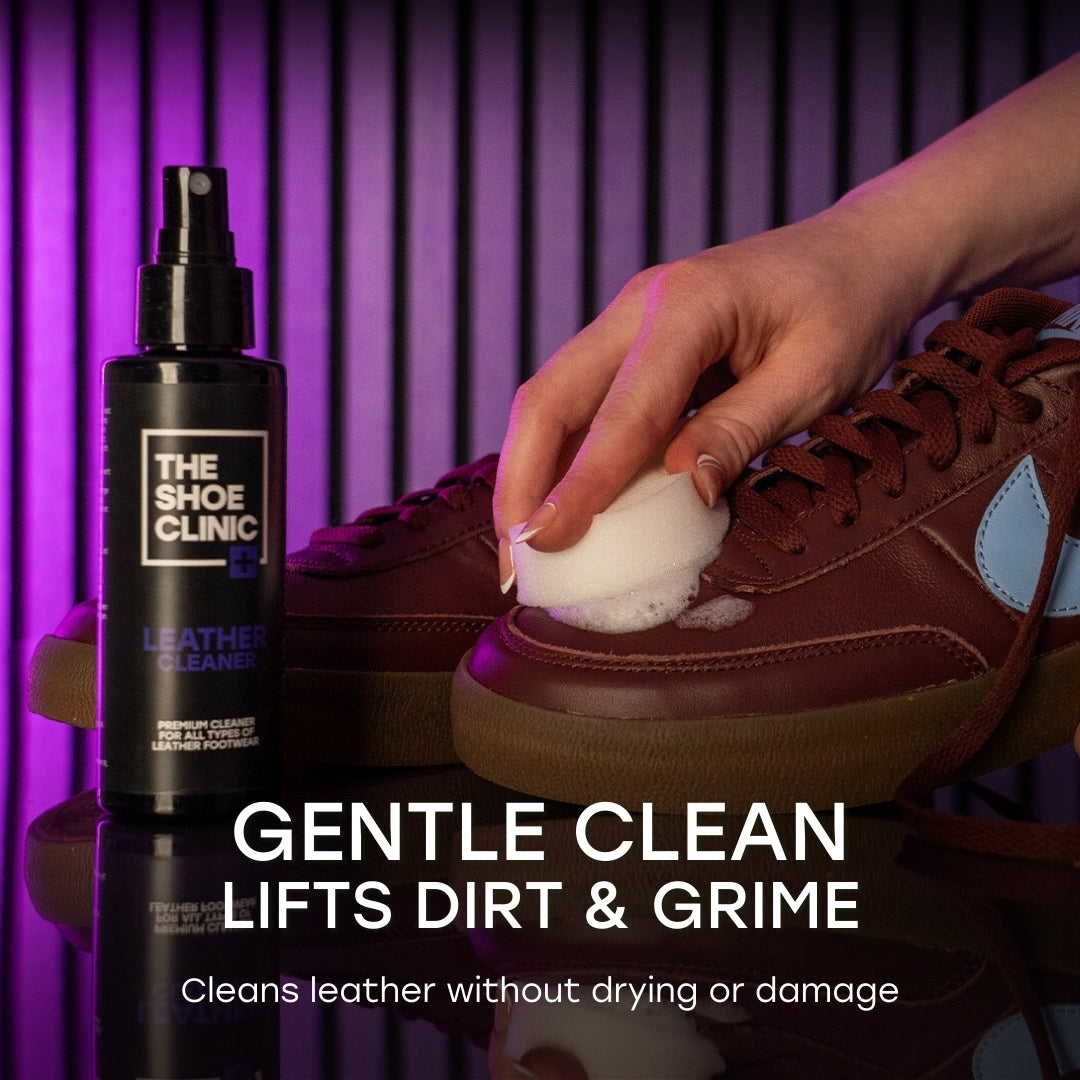 Person cleaning a brown leather shoe with a spray bottle labeled 'The Shoe Clinic, Leather Cleaner' on a purple background.