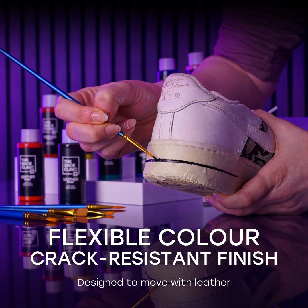 Person paint a sneaker with Shoe Clinic Leather Paint with coloured paints on a worktop and a coloured background