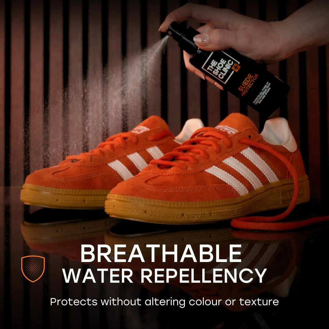 Person spraying Shoe Clinic Suede Protector on orange sneakers with text about breathable water repellency.
